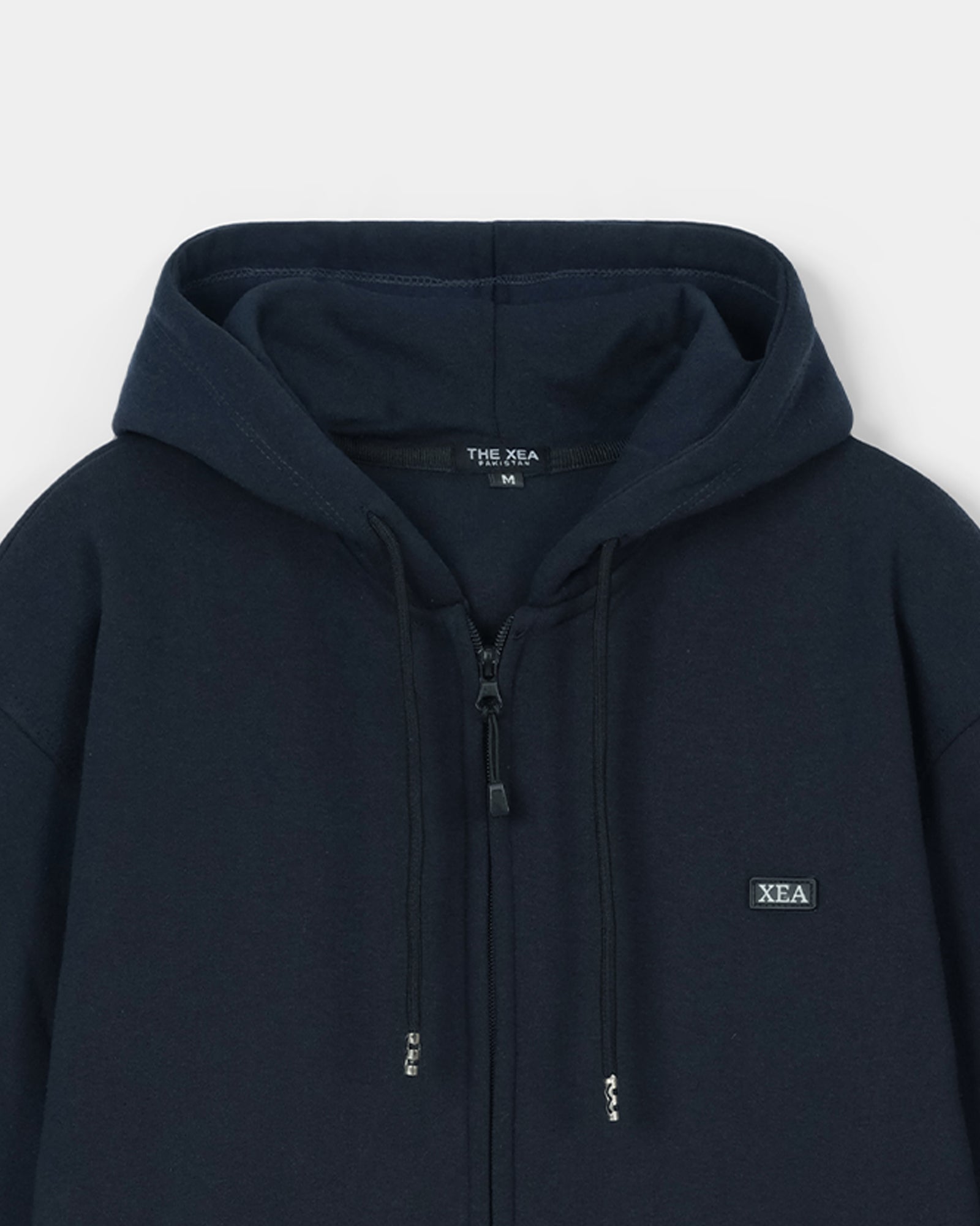 Navy hoodie with 'XEA' branding on a light gray background
