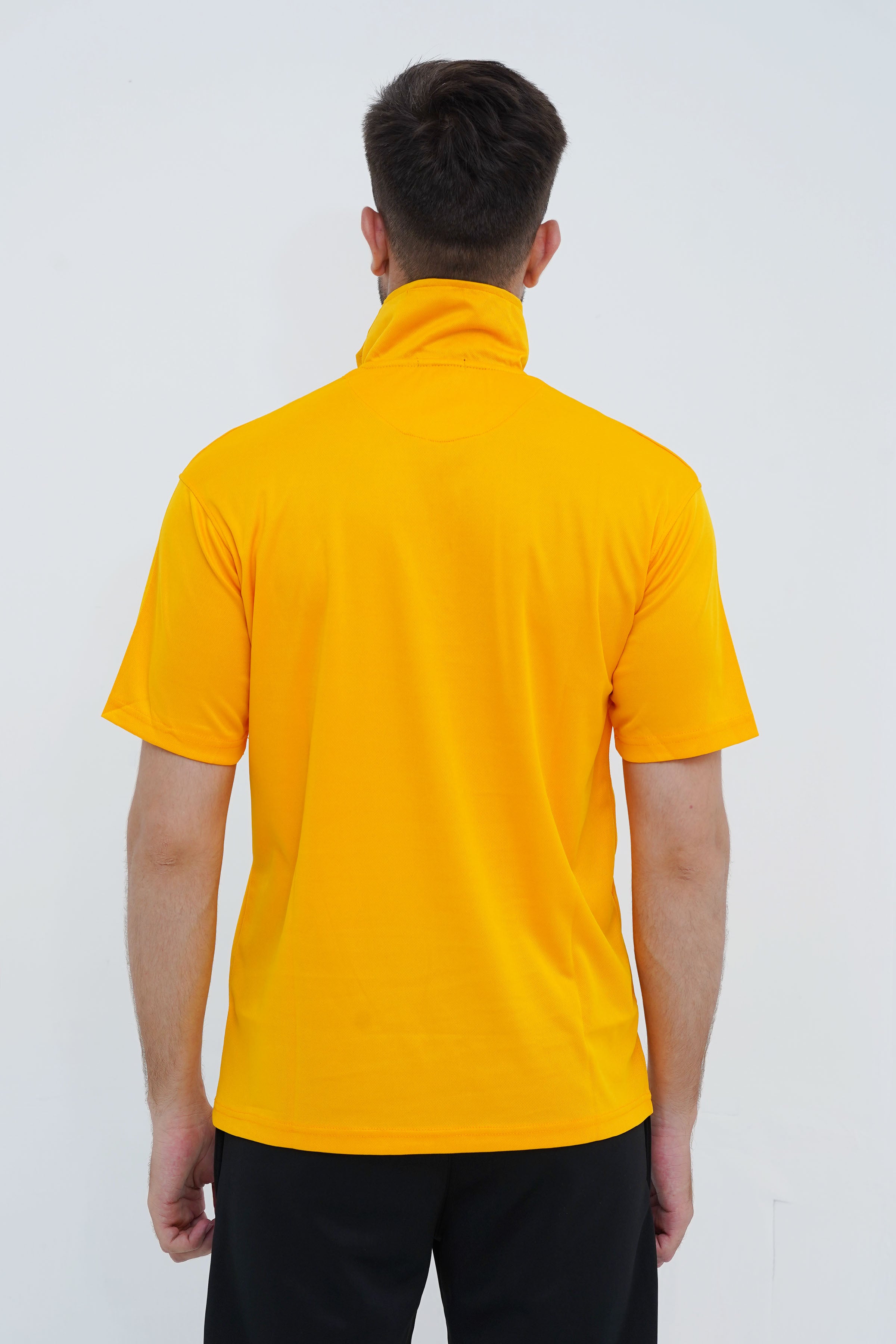 Person wearing a yellow polo shirt against a white background