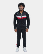 Man wearing a black tracksuit with red and white accents on a light gray background