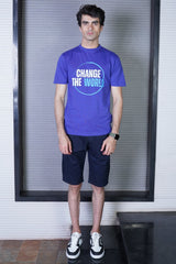 Person wearing a blue t-shirt with 'Change the World' text, standing indoors.