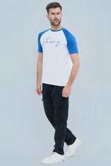 Man wearing a white and blue baseball shirt with 'strong' printed on it, standing against a light gray background.