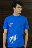 Man wearing a blue t-shirt with text against a wooden background