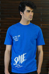 Man wearing a blue t-shirt with text against a wooden background