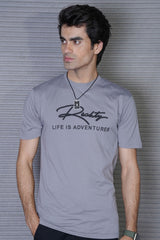 Man wearing a gray t-shirt with 'Rocky' branding and text against a striped background