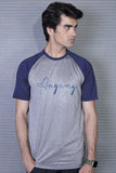 Man wearing a gray and navy baseball shirt with 'Anyway' text against a metallic background
