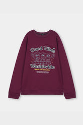 Maroon sweatshirt with 'Good Vibes Worldwide' text and cartoon characters on a light gray background