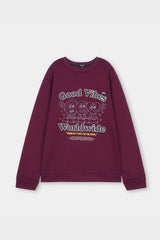 Maroon sweatshirt with 'Good Vibes Worldwide' text and cartoon characters on a light gray background