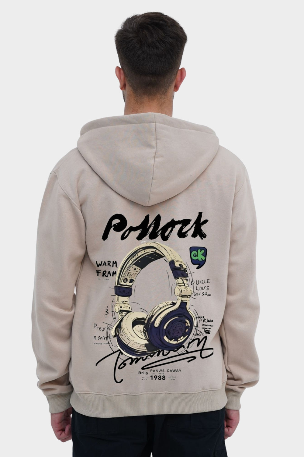 Person wearing a beige hoodie with a graphic design on the back, standing against a white background