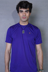Man wearing a purple shirt with a logo against a gray background
