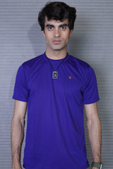Man wearing a purple shirt with a logo against a gray background