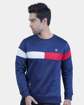 Man wearing a blue sweatshirt with red and white stripes on a light gray background