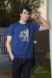 Man wearing a blue t-shirt with text and graphics, standing outdoors.