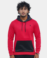 Man wearing a red and black hoodie with a logo on a light gray background