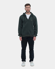Man wearing a green hoodie and black pants on a white background