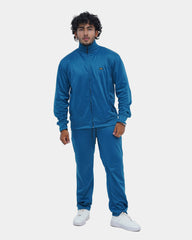 Man wearing a blue tracksuit on a light gray background