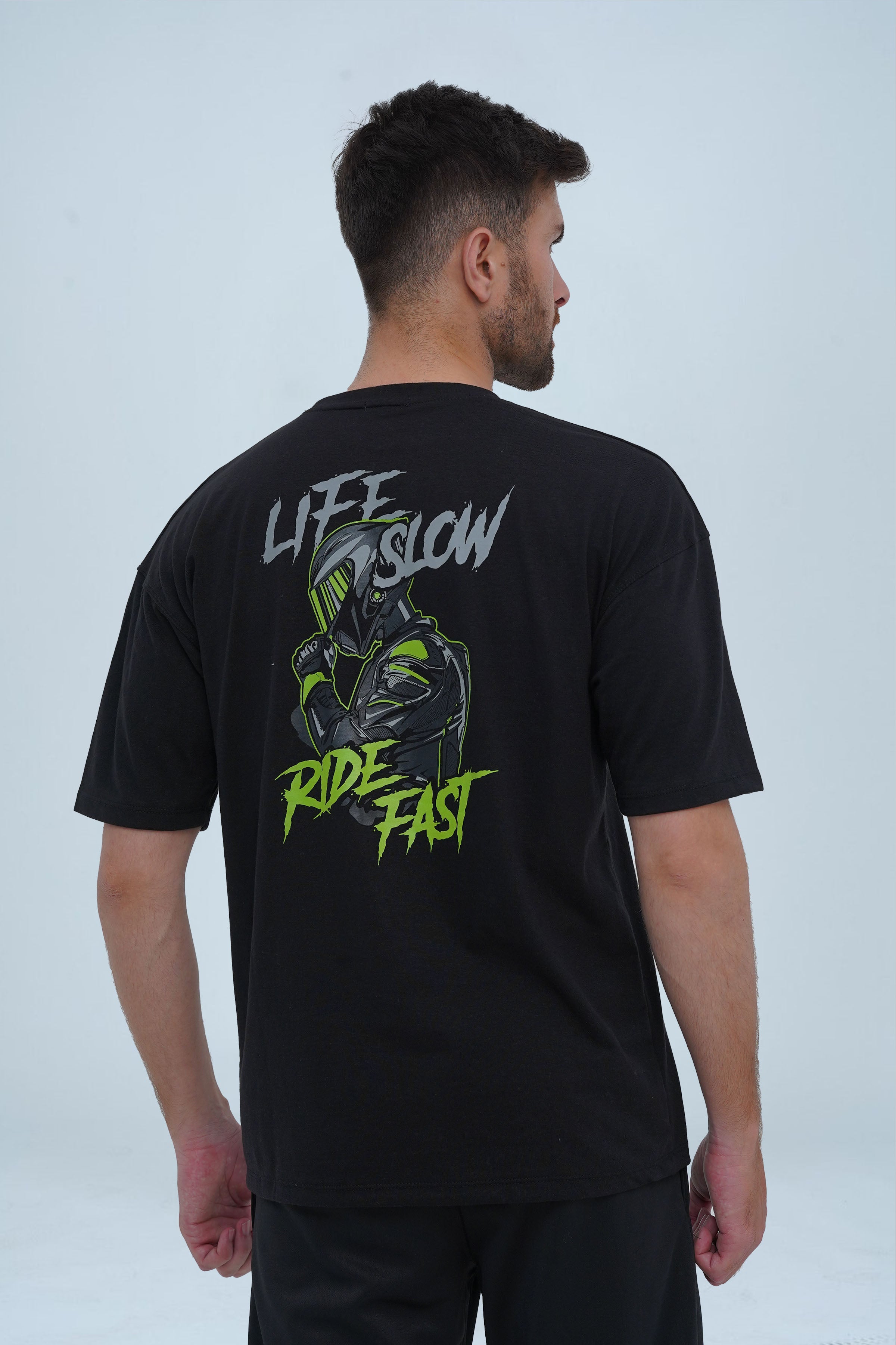 Men’s oversized black t-shirt featuring a bold "Life Slow, Ride Fast" graphic with a biker illustration on the back.