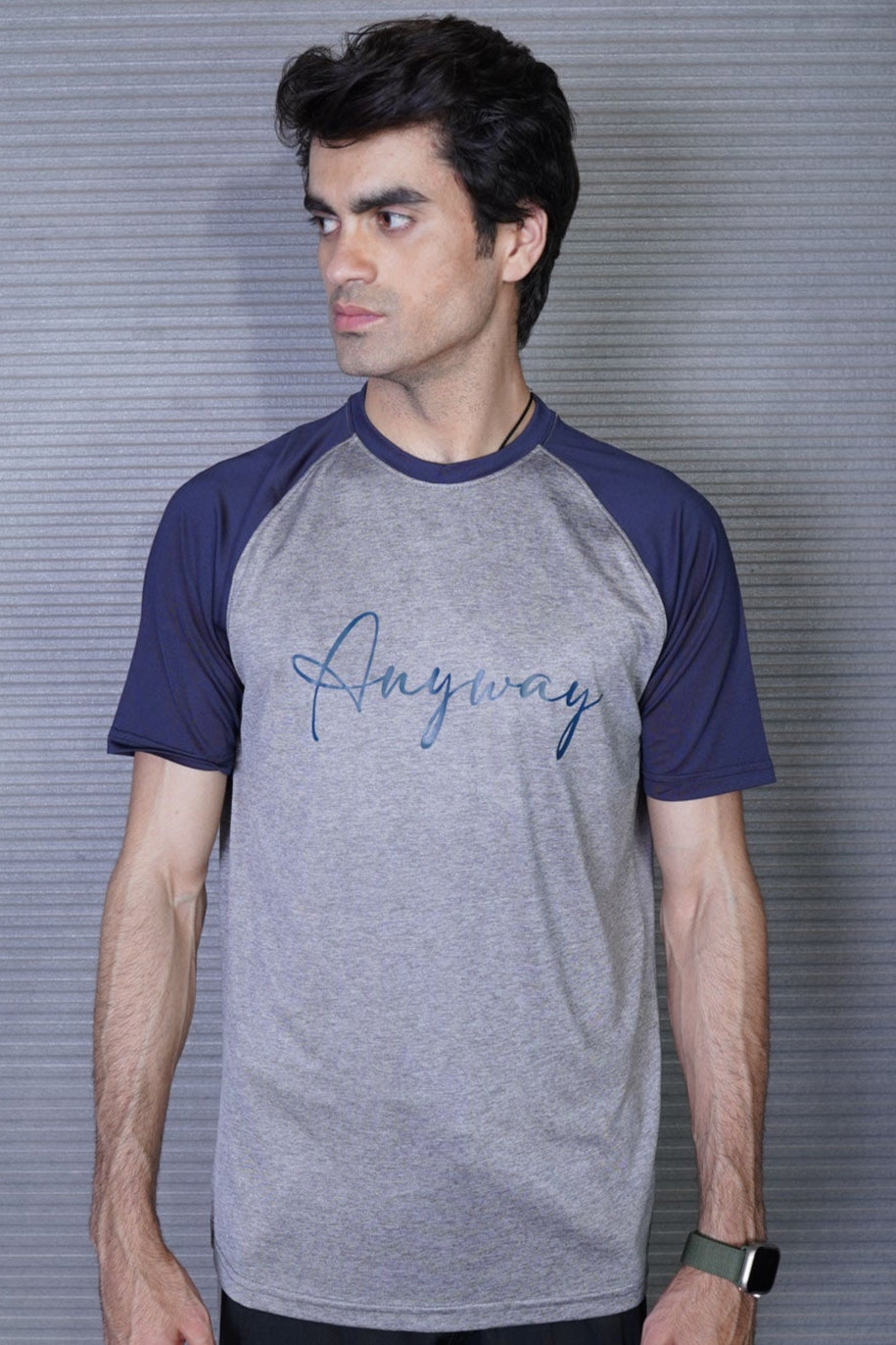 Man wearing a gray and navy baseball t-shirt with 'Anyway' text against a metallic background