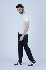 A man wearing black jogger pants with royal blue stitching and a visible brand logo on the upper left thigh.