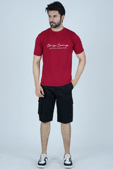 A man wearing a red t-shirt with the text 'Praise Courage' standing against a plain background.