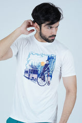 A male model wearing a white crew neck t-shirt with a vintage scene 3D print, standing against a light blue background.