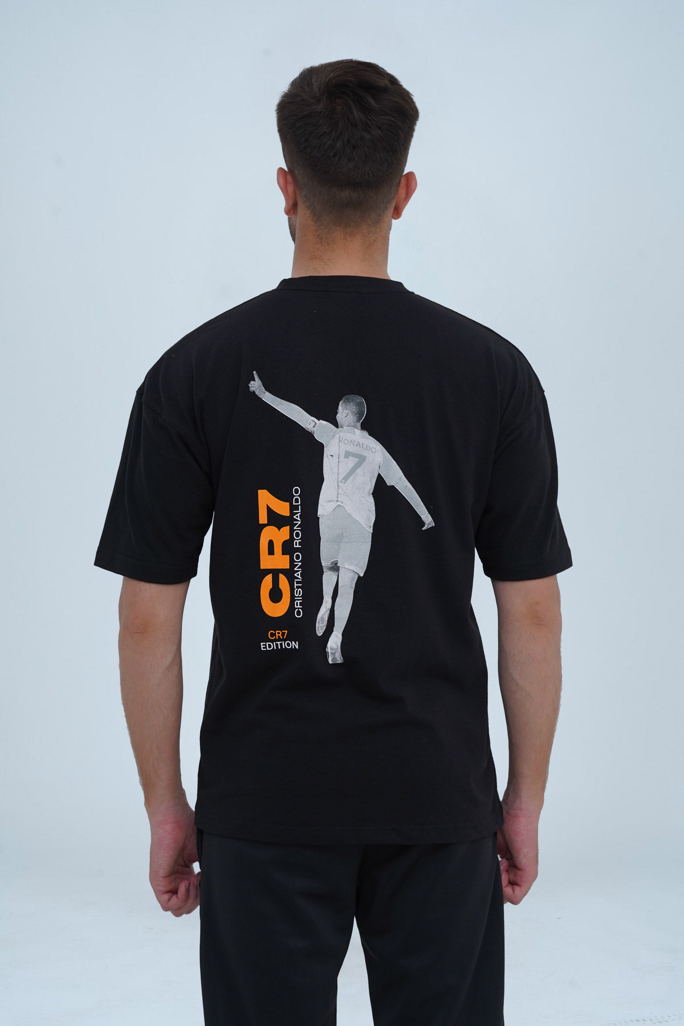 XEA CR7 Edition oversized t-shirt in black with a drop-shoulder fit, front vertical branding, and a back graphic capturing Ronaldo’s legendary celebration. A must-have for football and streetwear fans.