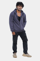 Man wearing a gray hoodie and dark pants on a white background