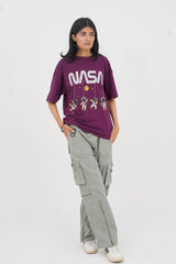Person wearing a purple NASA t-shirt and gray cargo pants on a white background