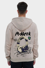 Person wearing a beige hoodie with a graphic design on the back, standing against a white background
