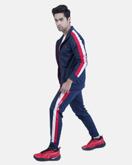 Man wearing a navy tracksuit with red and white stripes on a light blue background