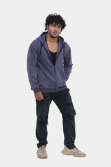 Man wearing a purple hoodie and dark pants on a white background